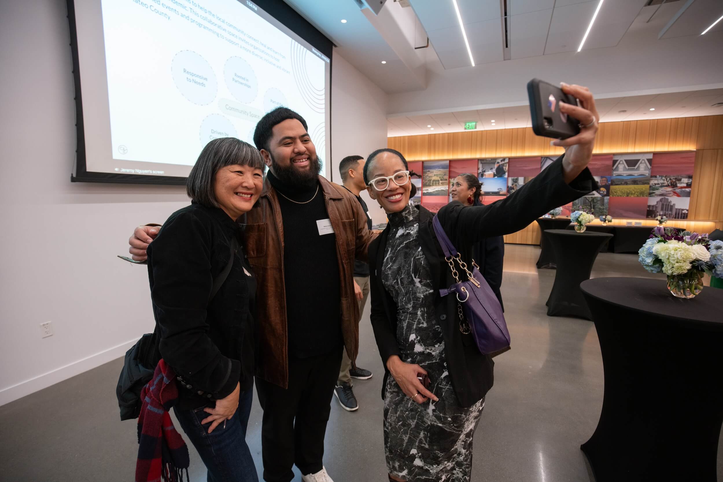 Three people pose for a selfie in the event space.