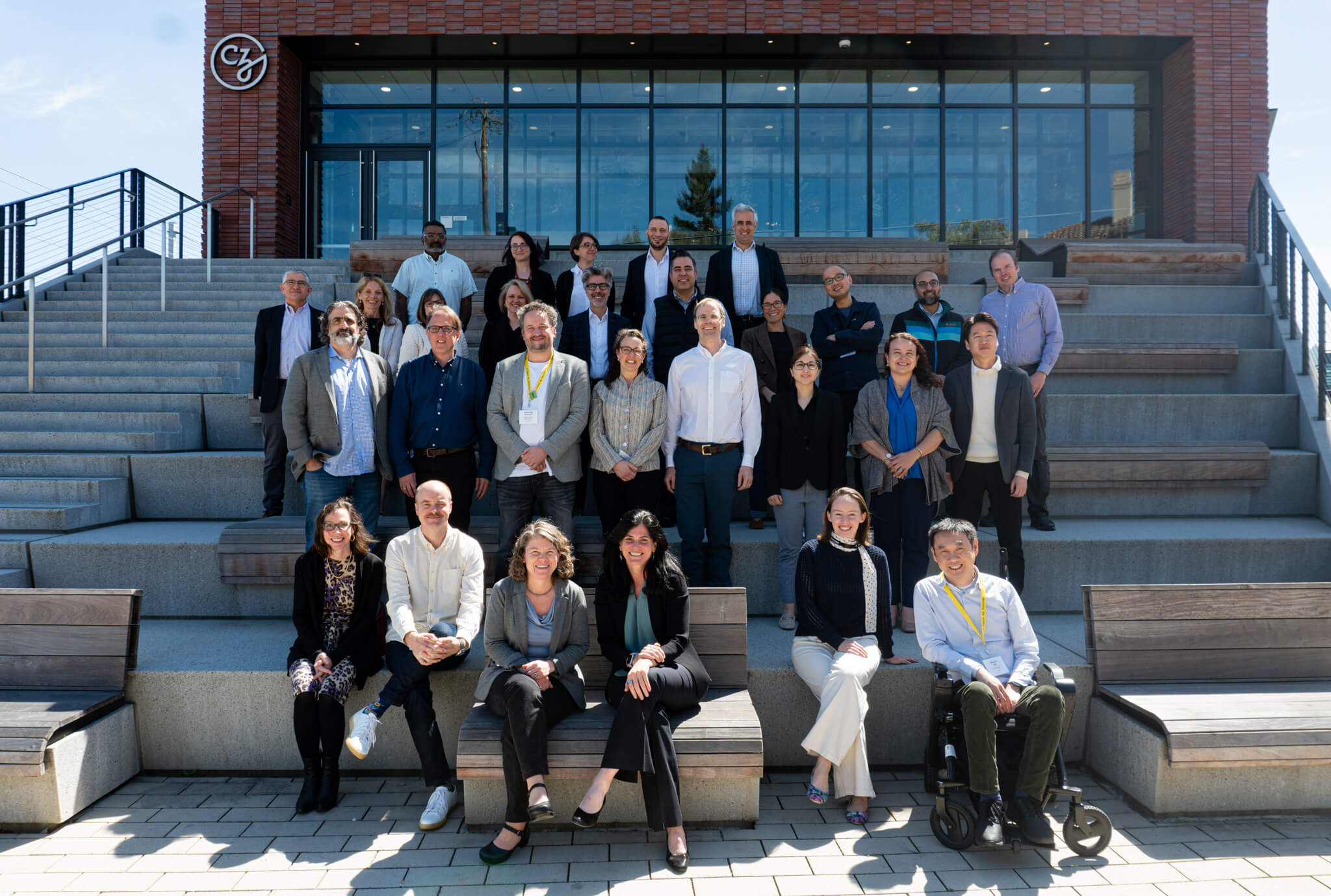 Group photo of attendees at the 2025 ‘Unlocking Patterns’ rare disease workshop, posed on outdoor steps in front of the CZI building.